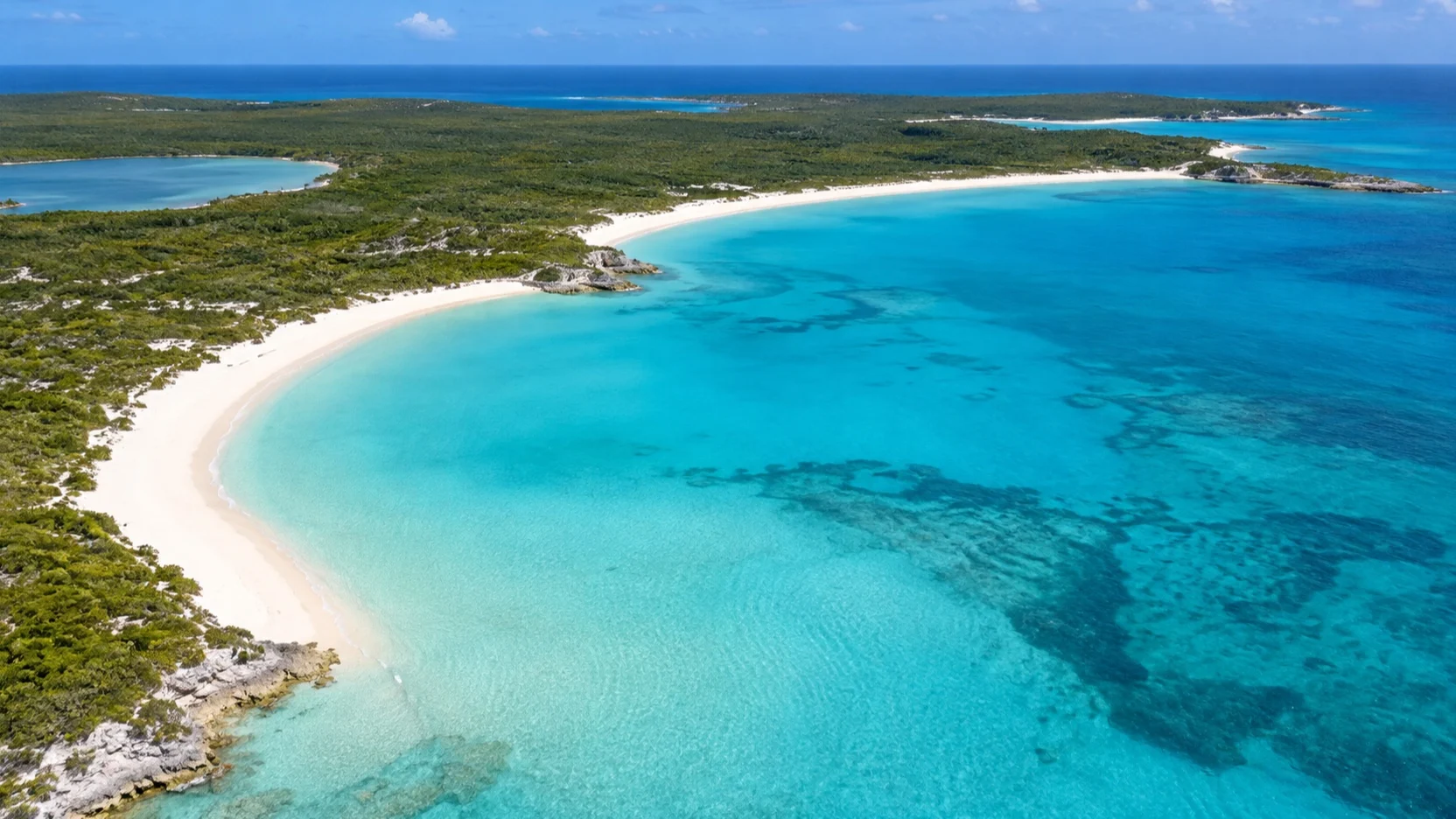 Aerial view of Half Moon Cay’s curved beach and turquoise bay