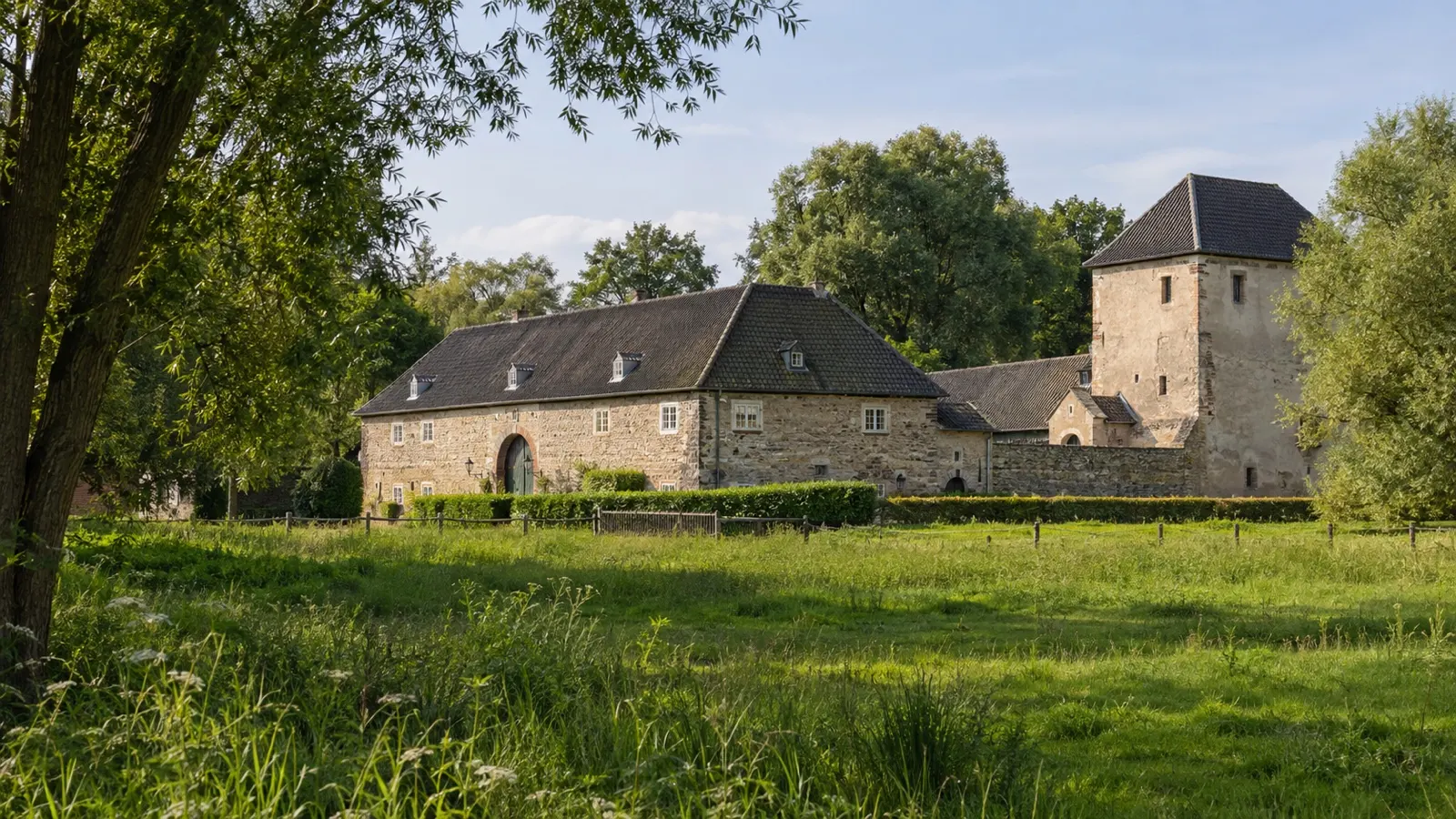 Historic Haus Bürgel building in a green floodplain near Monheim