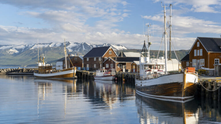 Boats and wooden harbor buildings in Húsavík Iceland