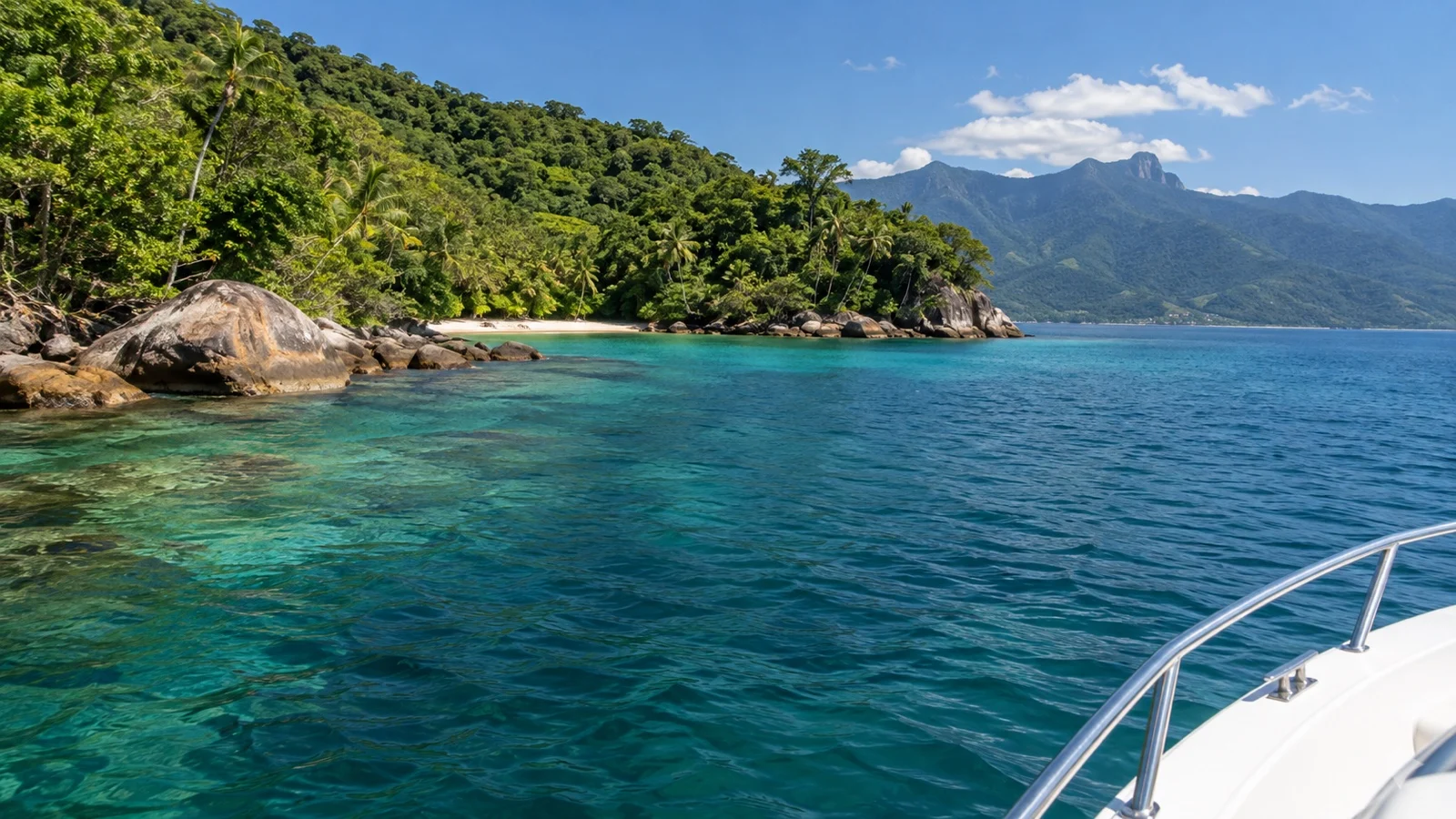 Small boat near tropical coves along Ilhabela