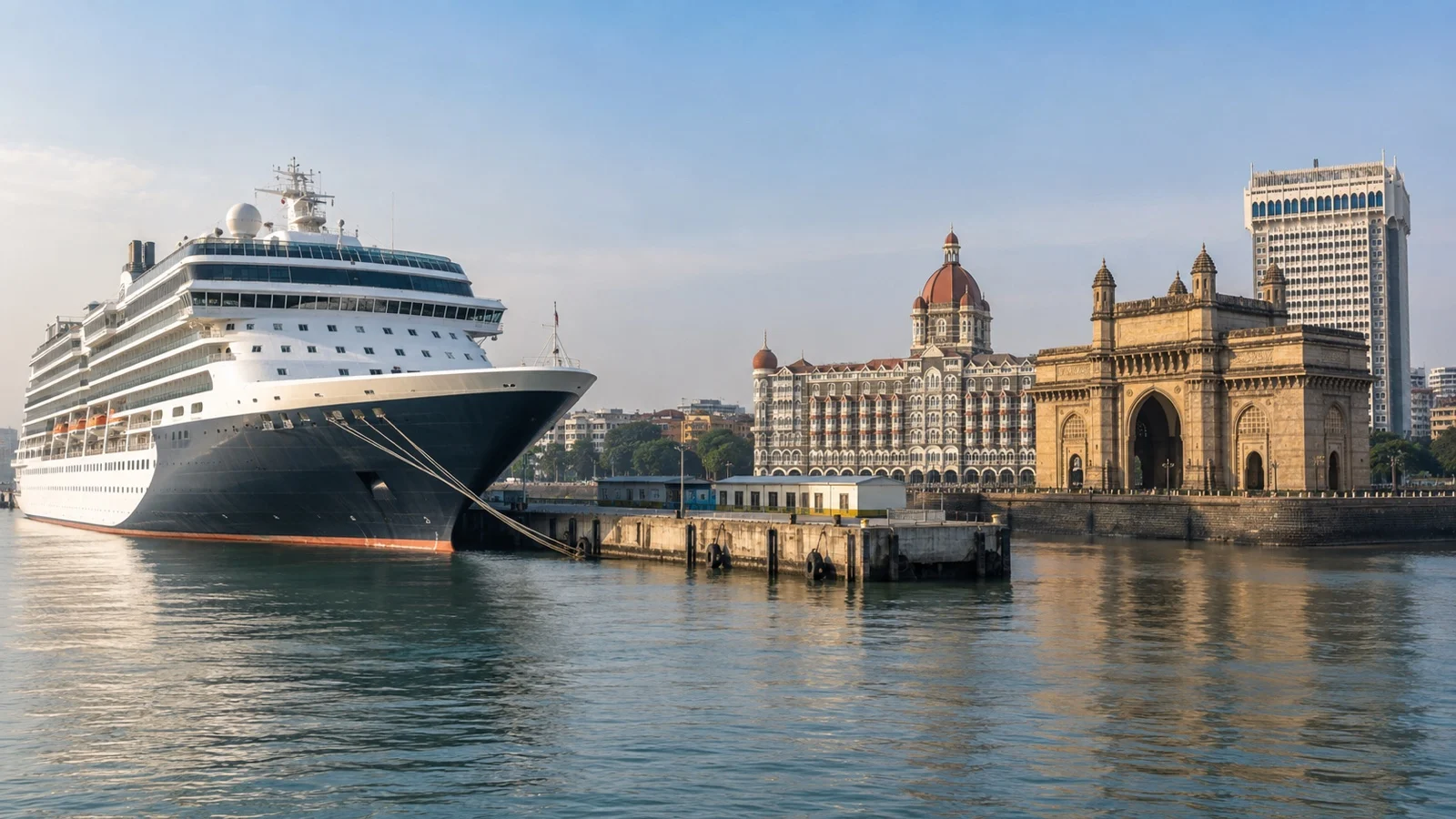 Cruise ship docked at an Indian port with city waterfront beyond
