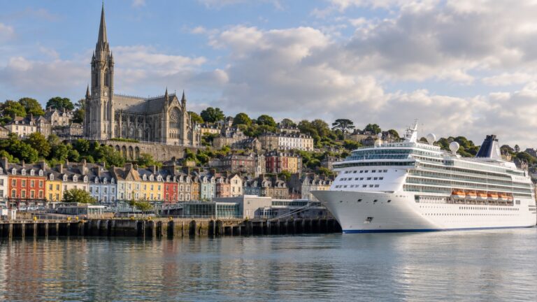 Cruise ship beside Cobh's colorful waterfront and cathedral in County Cork