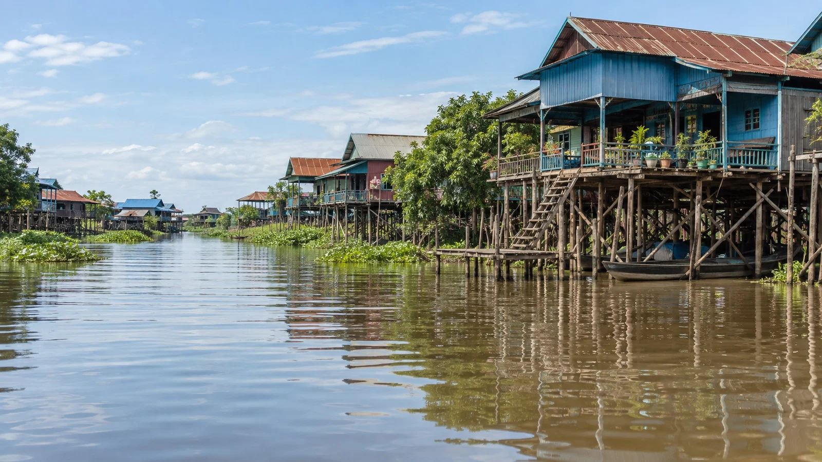 Stilted Cambodian houses along high-water Tonle Sap river channel near Kampong Chhnang, no people