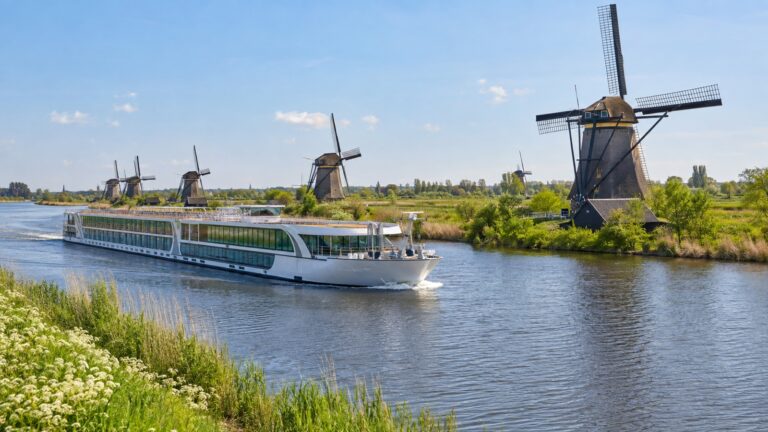 River cruise ship near Kinderdijk windmills in spring