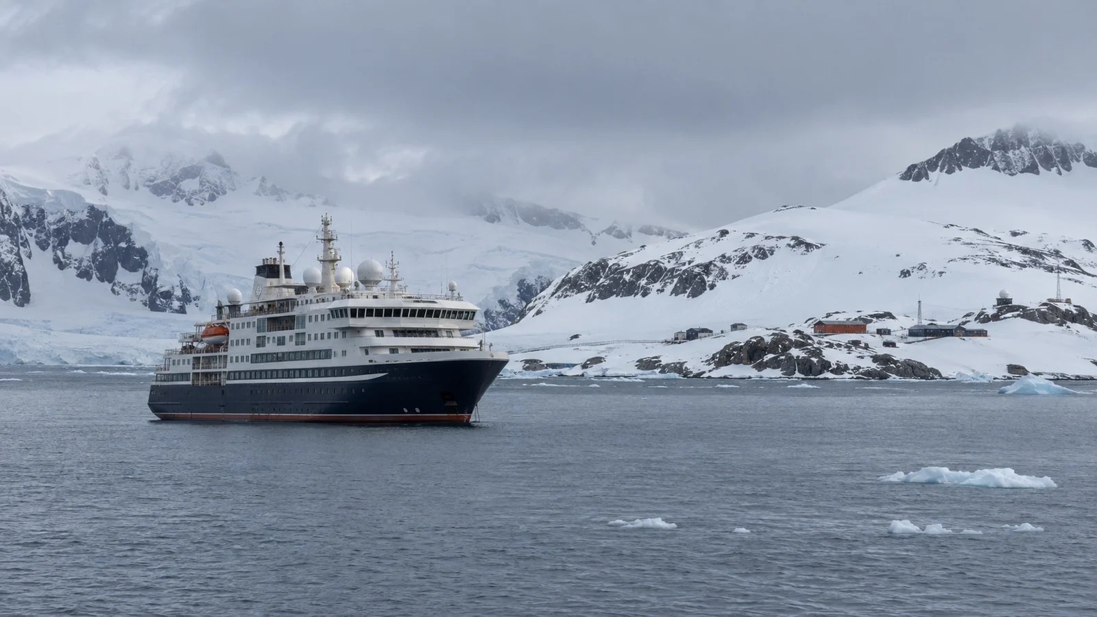 Antarctic expedition cruise ship offshore from King George Island among cold gray water and low snowy hills