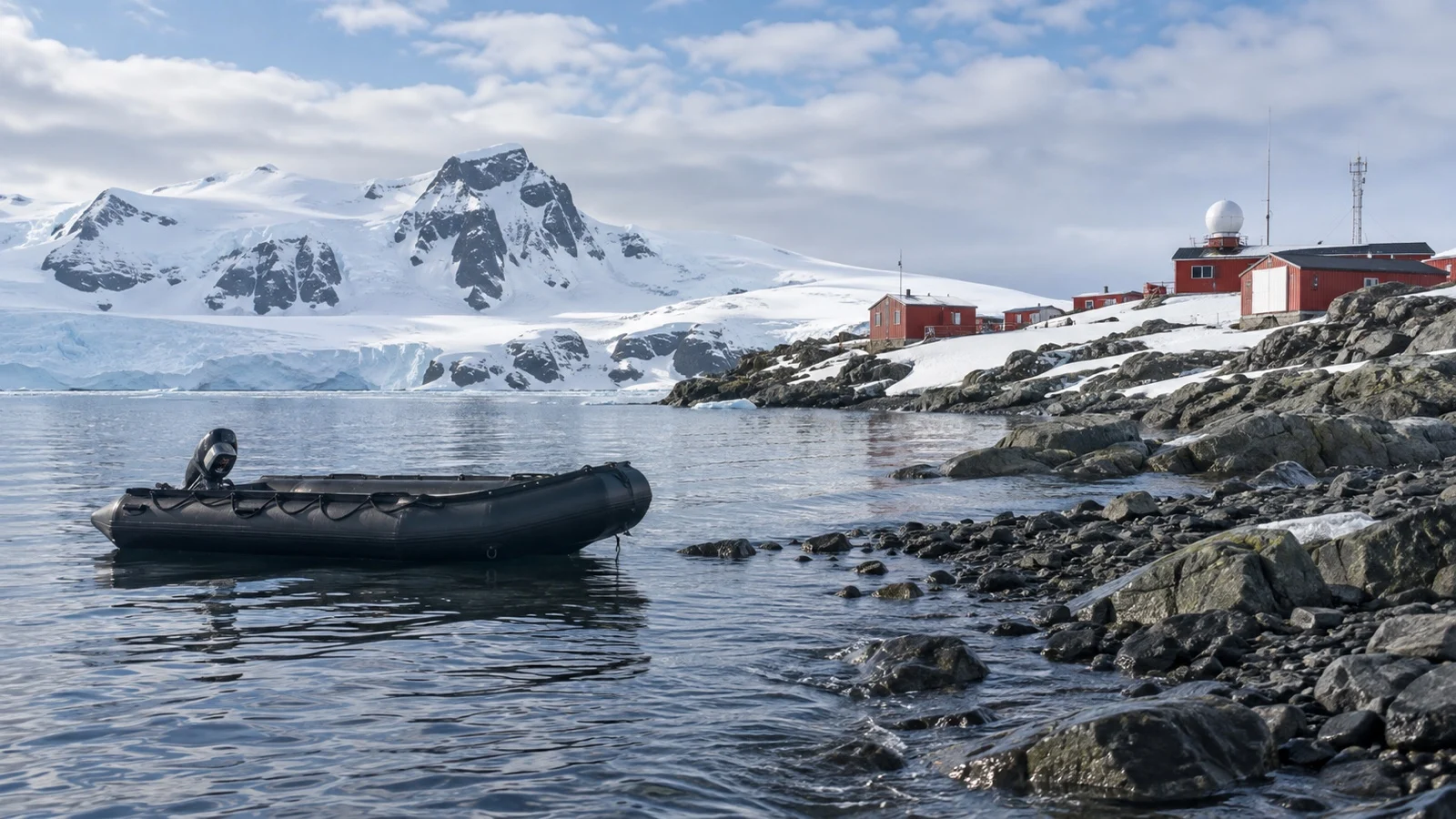 Empty inflatable Zodiac boat floating beside a rocky Antarctic landing on King George Island