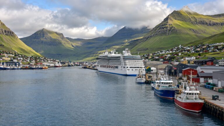Cruise ship at Klaksvík quay beneath steep green mountains