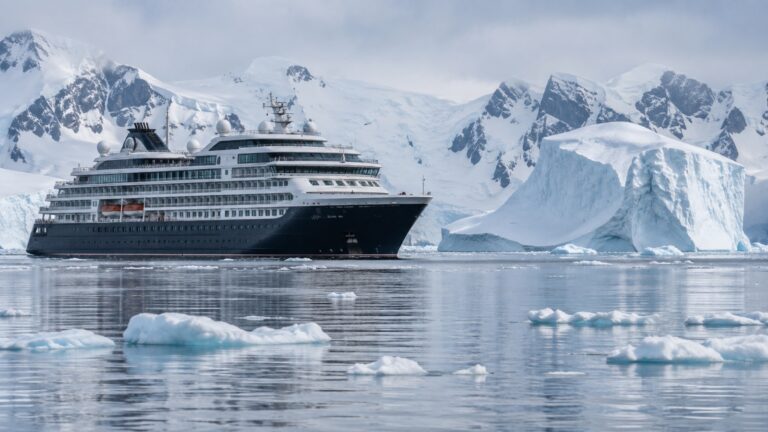 Large cruise ship sightseeing among Antarctic icebergs