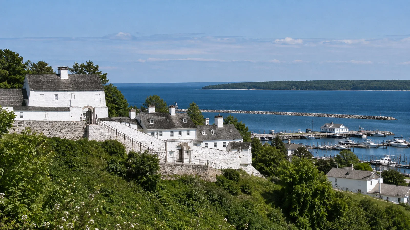 Fort Mackinac white historic fort buildings above Mackinac Island harbor and blue Lake Huron, no people
