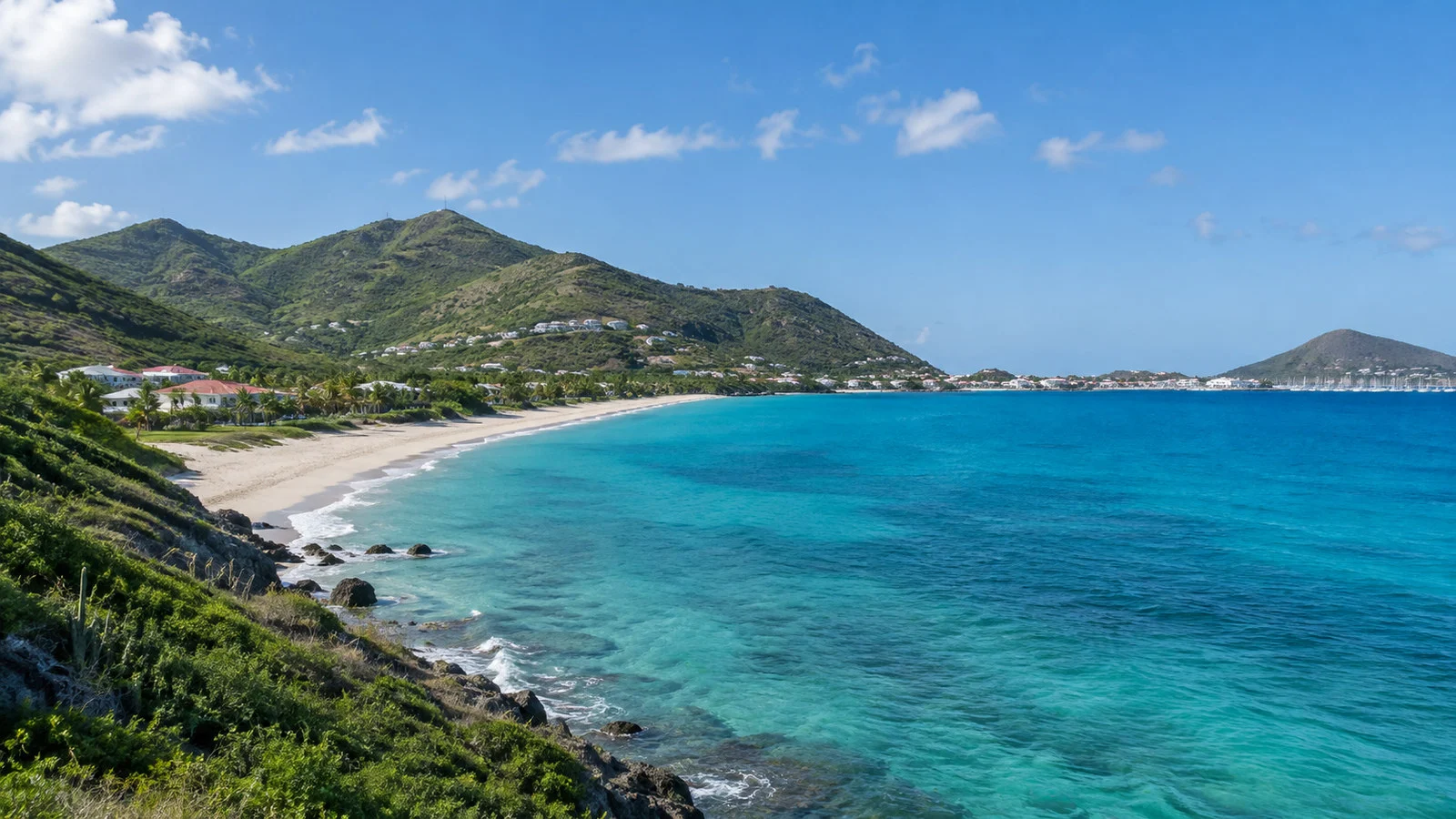 Saint Martin coastline near Marigot with green hills, sandy beach and turquoise Caribbean water, no people