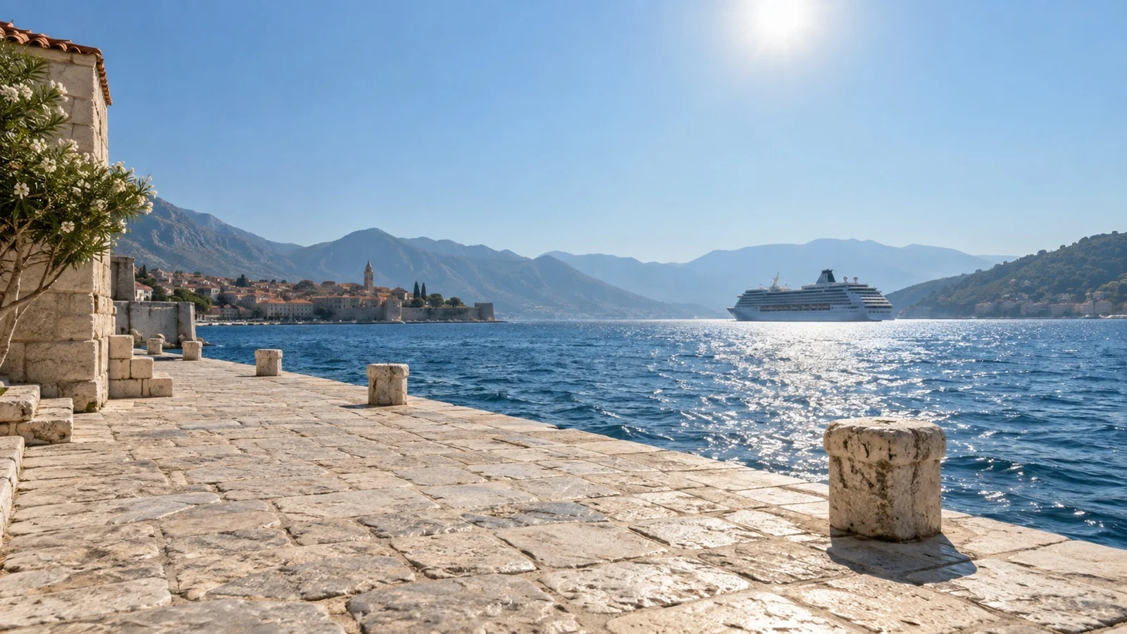 Sun-baked stone quay and cruise ship on a hot Mediterranean August day
