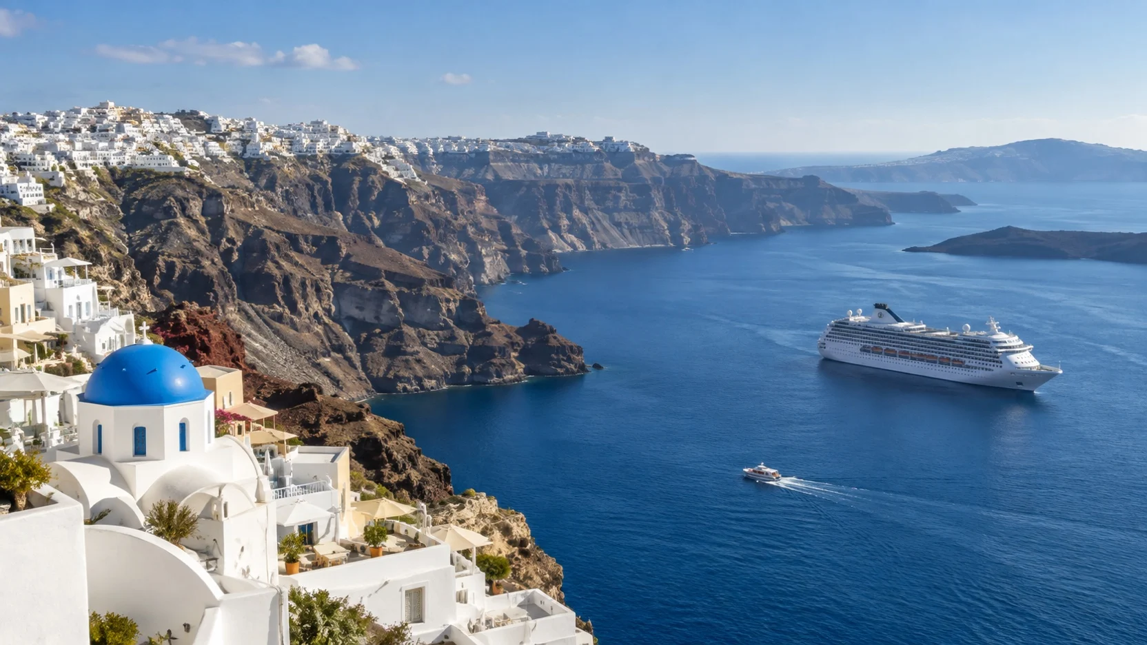 Cruise ship and tender in Santorini’s caldera below whitewashed villages