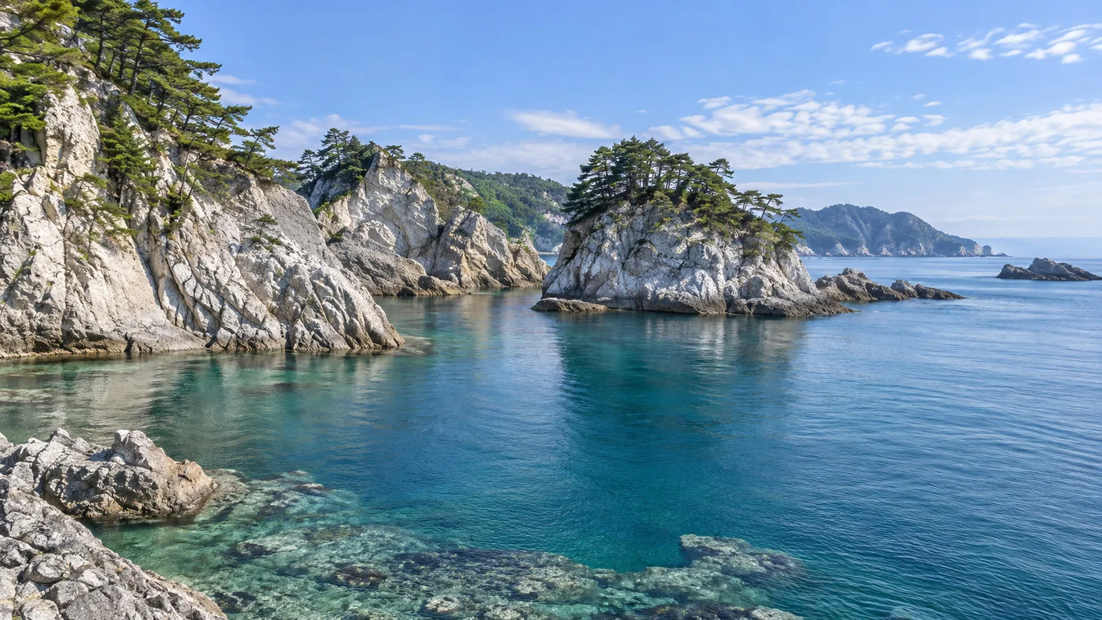 Jodogahama Beach Miyako Japan white rocky cliffs and pine-covered islets above clear sea, no people
