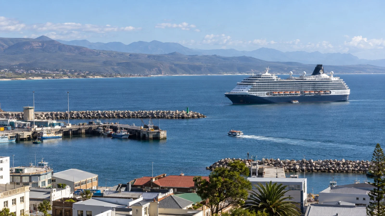 Cruise ship anchored off Mossel Bay with a tender crossing toward the harbor