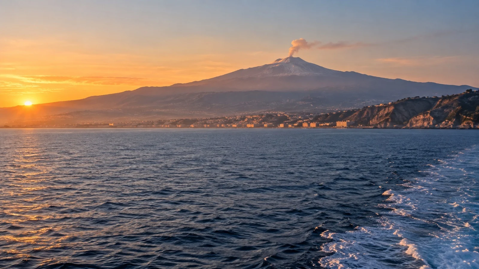 Mount Etna rising behind Sicily with a steam plume visible from the Strait of Messina.