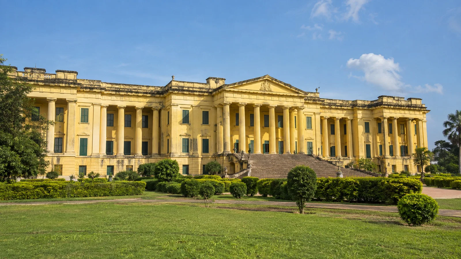 Yellow colonnaded facade of Hazarduari Palace in Murshidabad