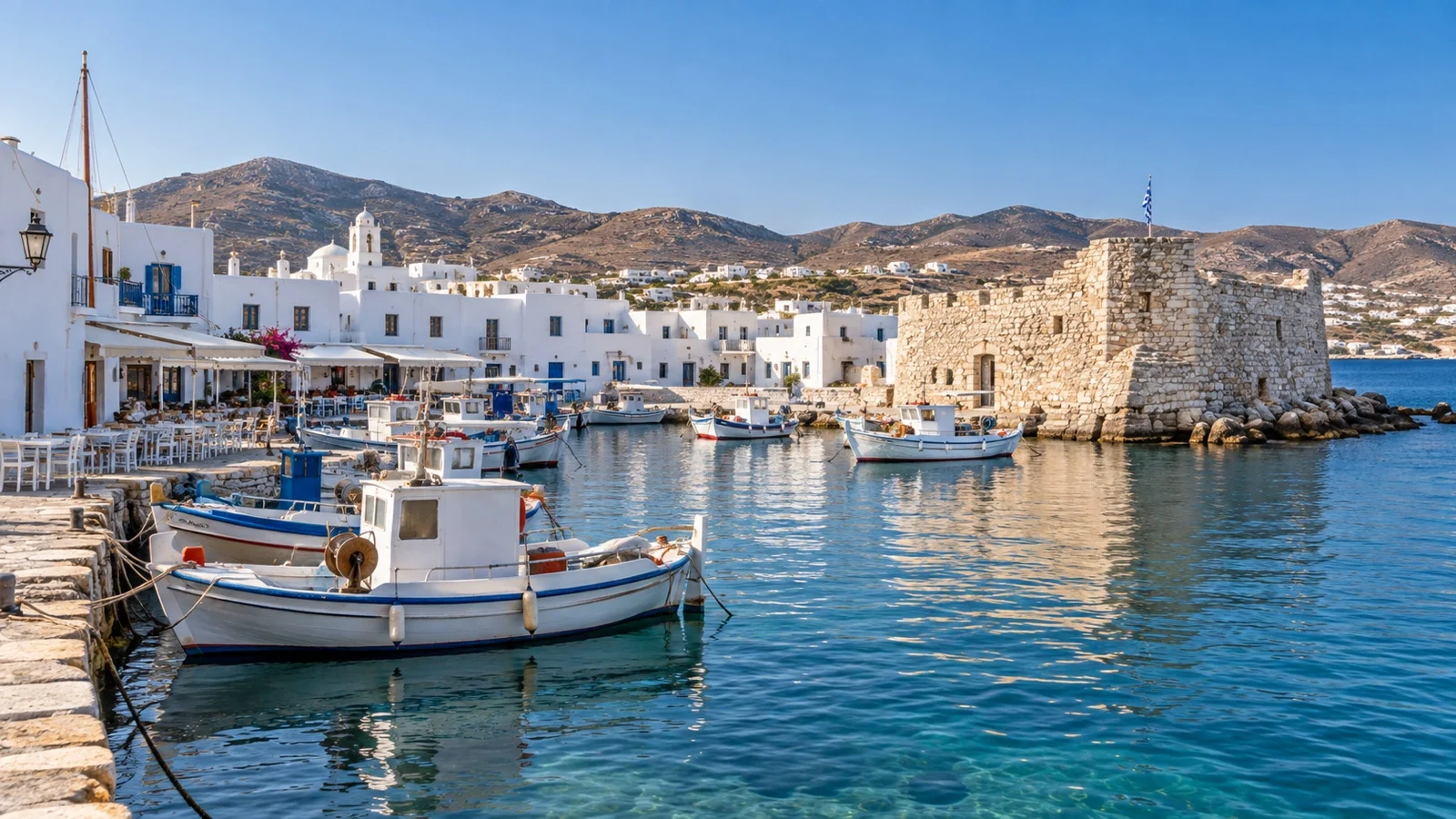 Fishing boats and white buildings at Naoussa harbor on Paros