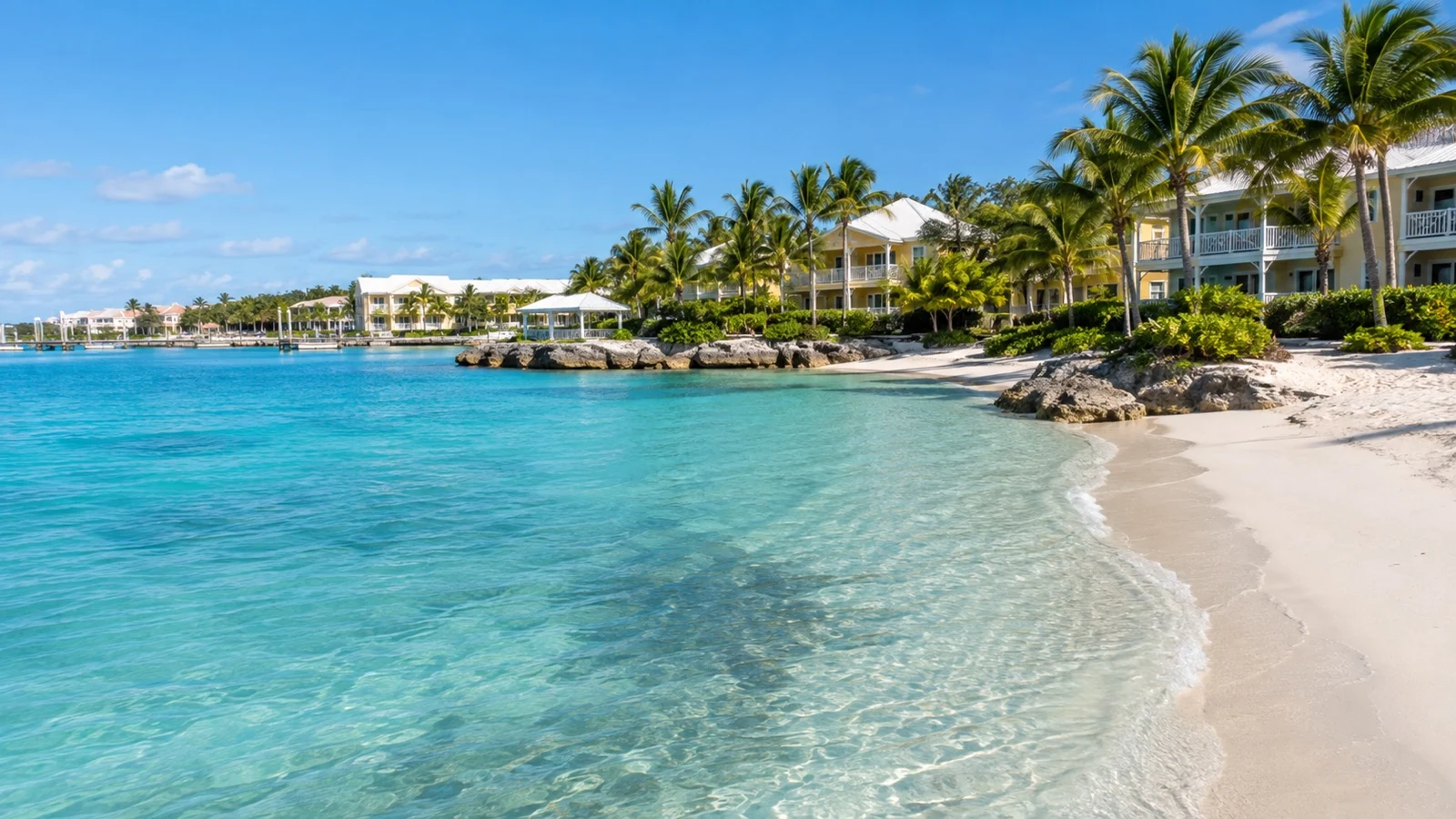 Paradise Island resort waterfront in Nassau with low-rise hotel buildings, white sand and clear blue water