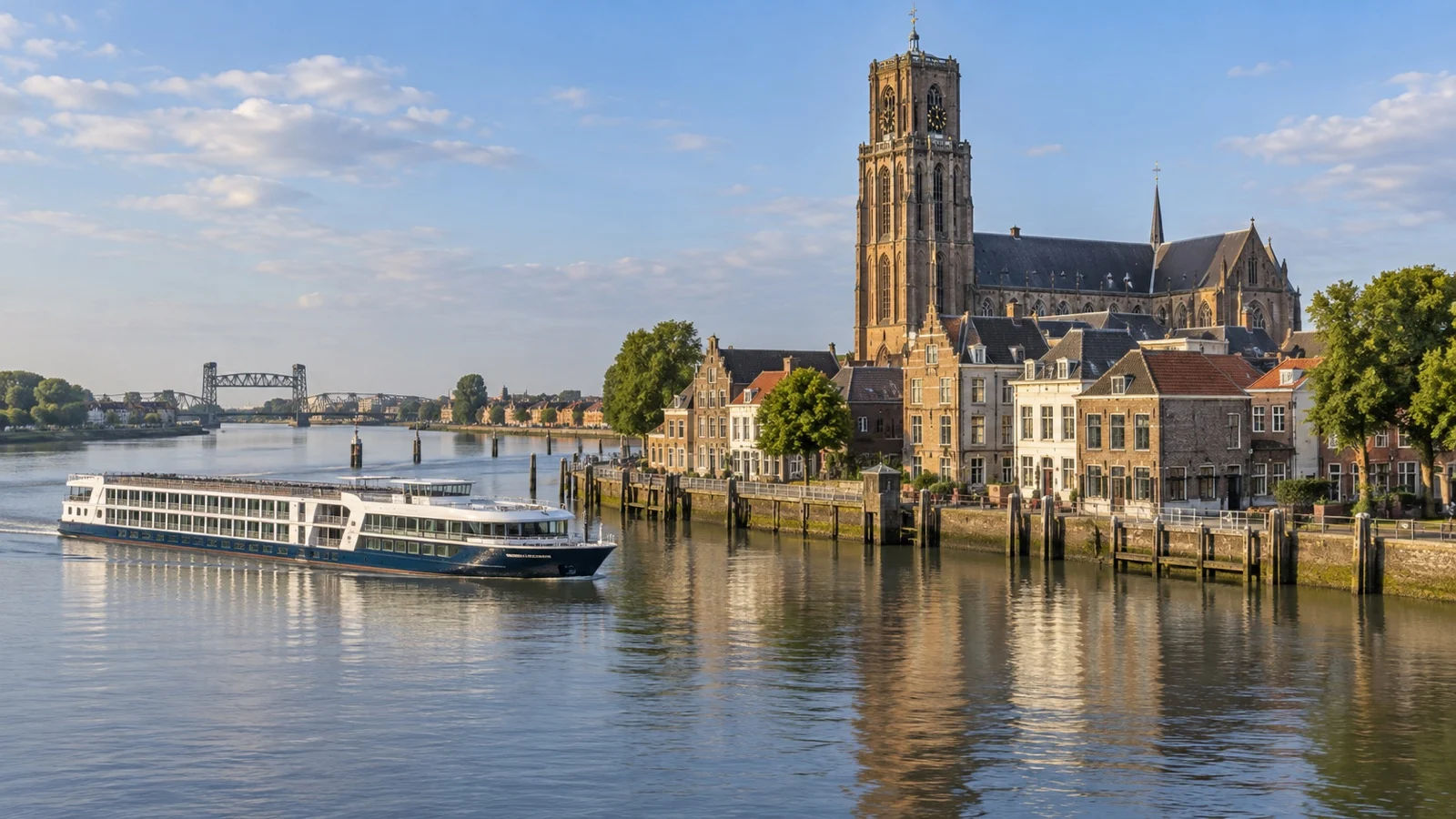 Small river cruise ship near Dordrecht's historic harbor and old Dutch waterfront buildings