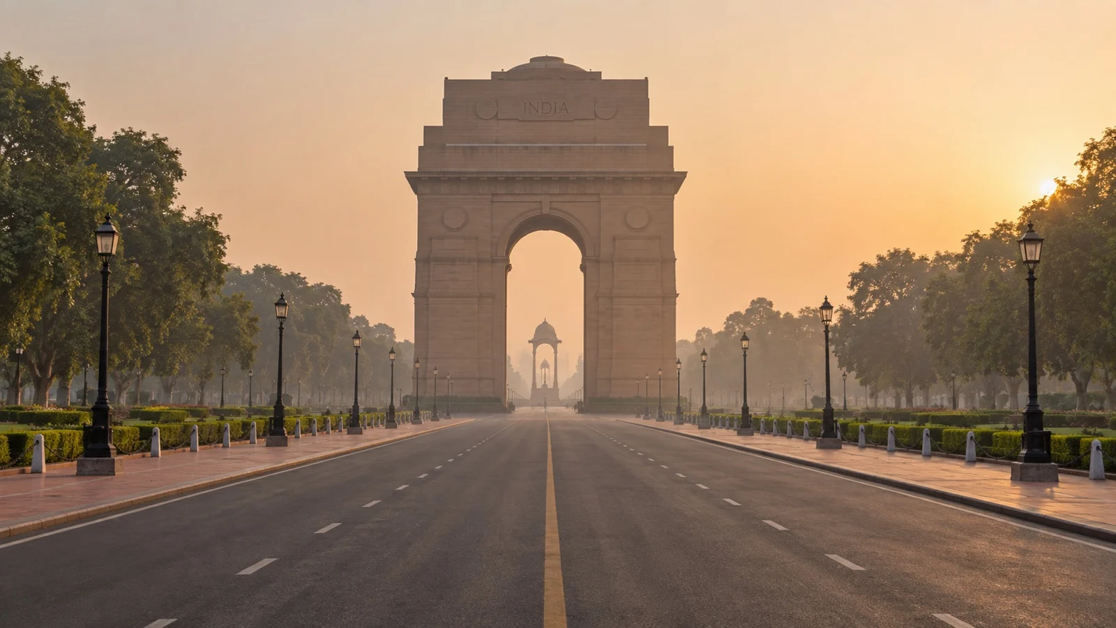 India Gate on a deserted tree-lined avenue in New Delhi