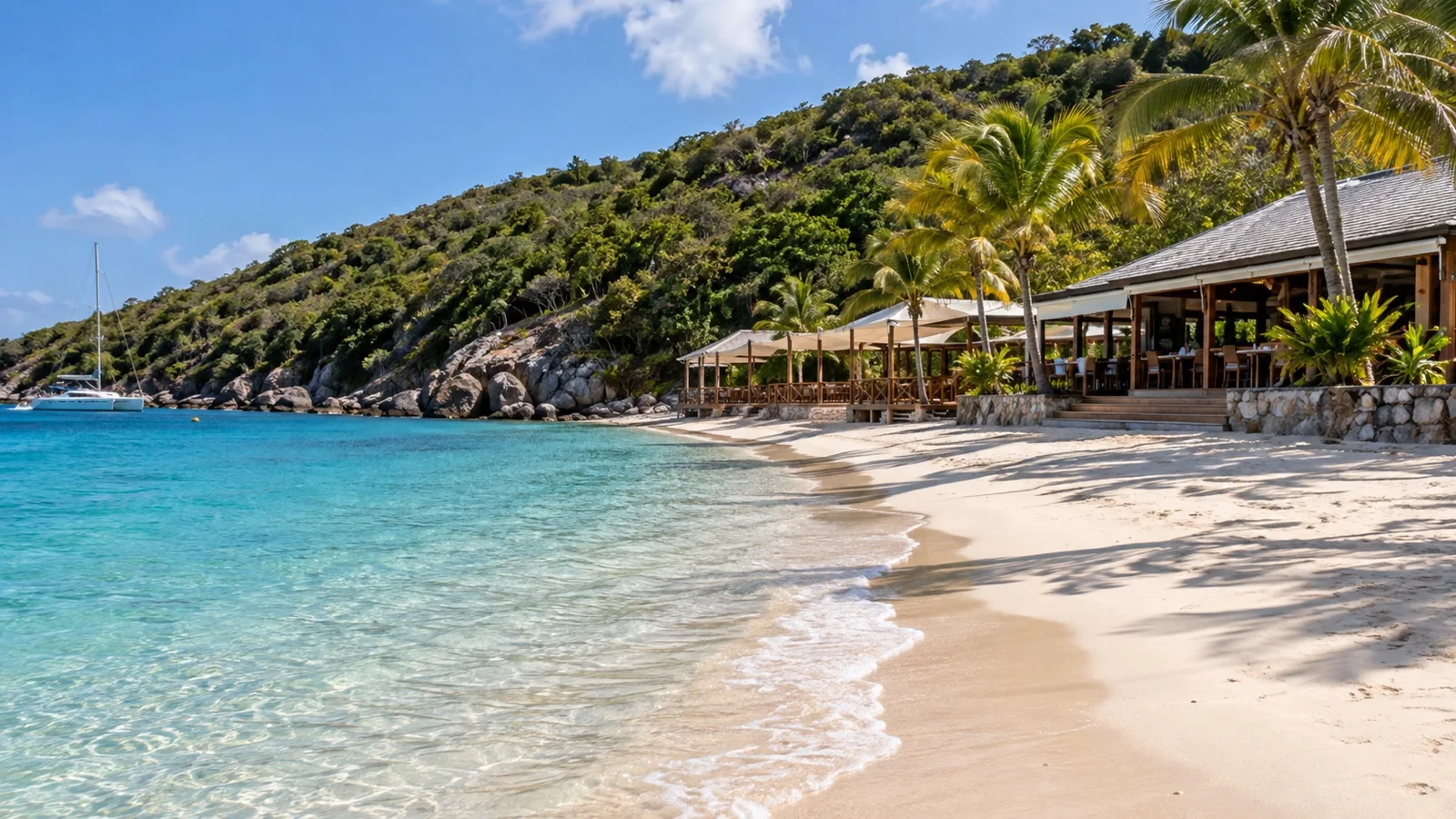 Empty sandy beach and beach club buildings at Pirate’s Bight on Norman Island