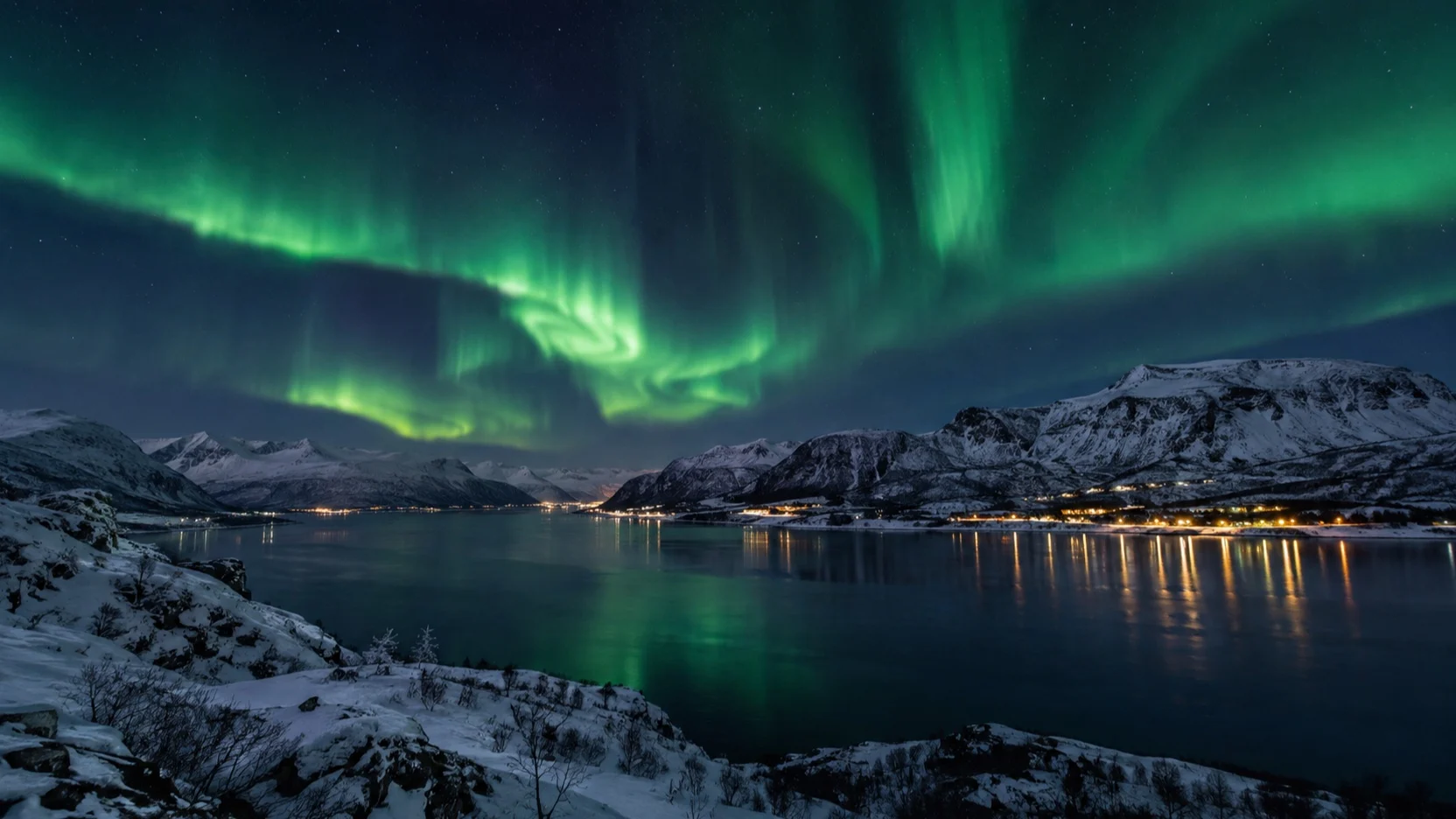 Green aurora above a snowy fjord near Alta, Norway