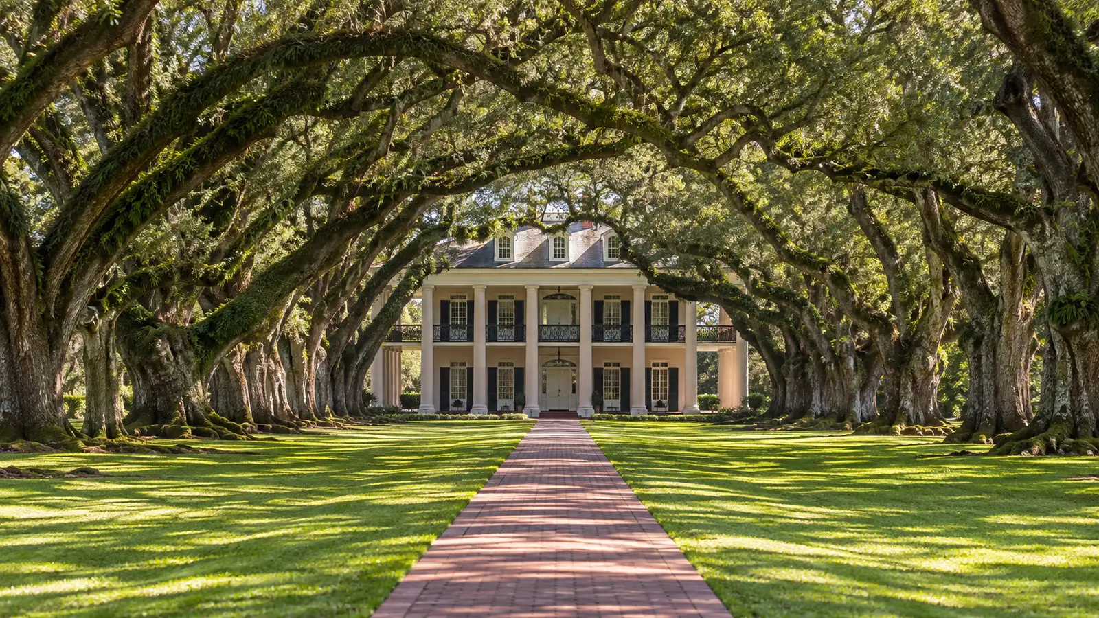 Oak Alley Plantation Louisiana Big House framed by the famous double row of mature live oak trees from the garden path, no people