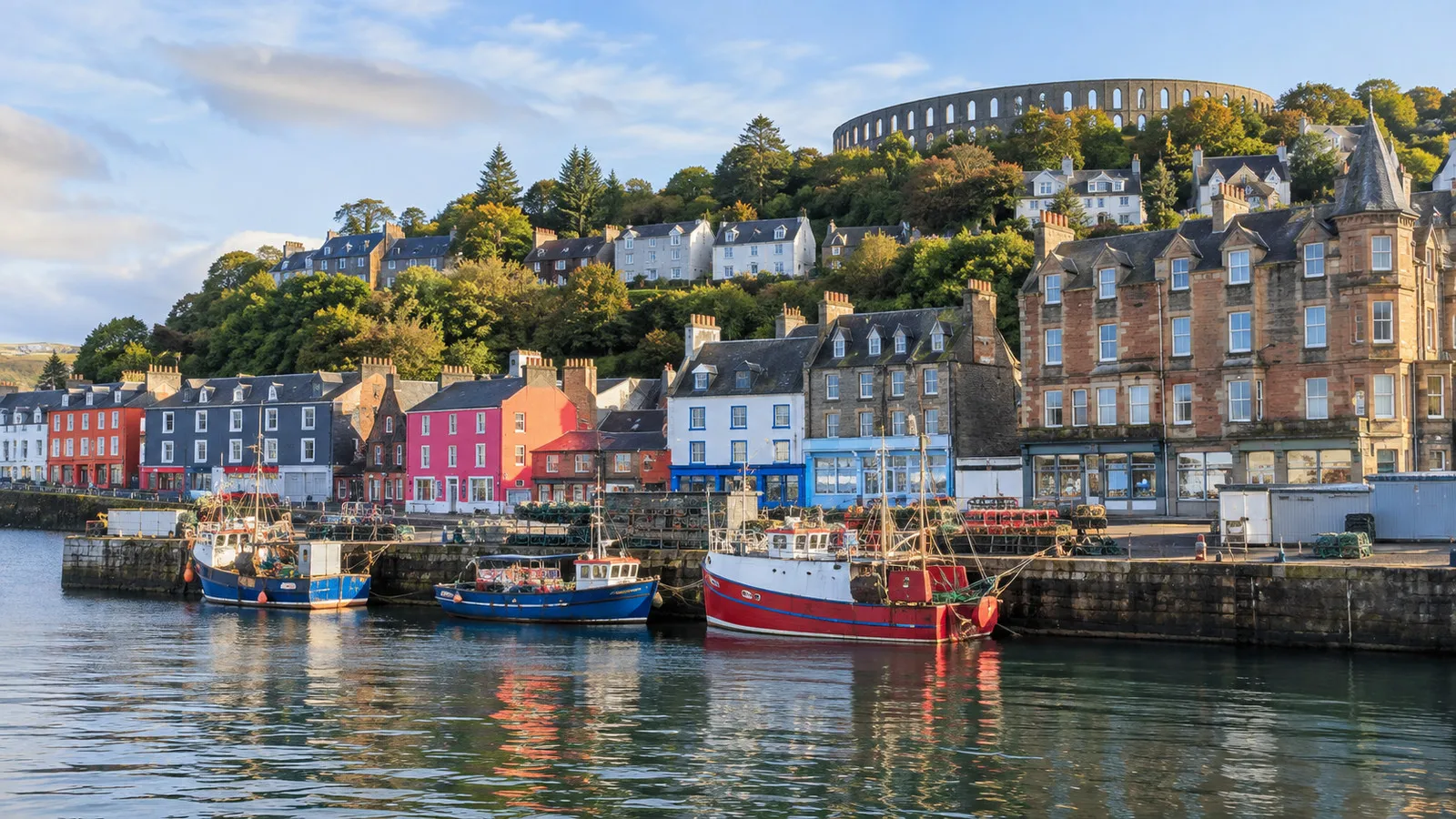 Fishing boats and colorful buildings along Oban waterfront