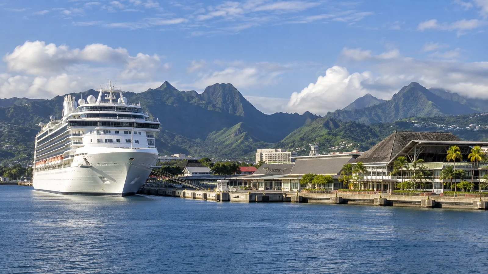 Cruise ship docked at Papeete waterfront on Tahiti with green volcanic mountains