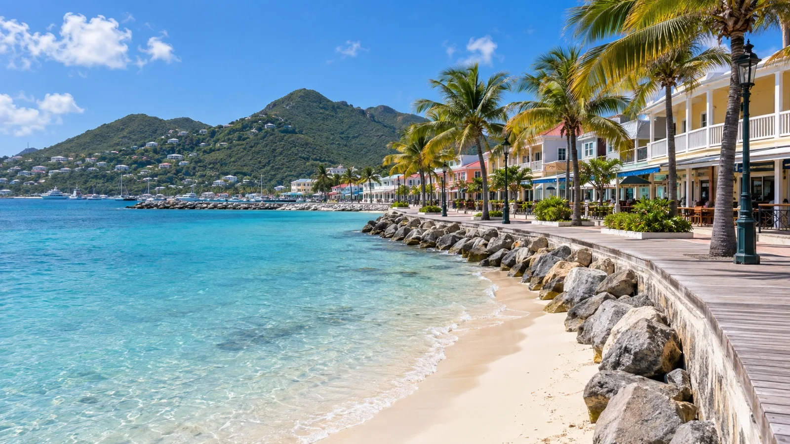 Great Bay beachfront and Philipsburg boardwalk, low waterfront hotels, calm turquoise sea and palm trees