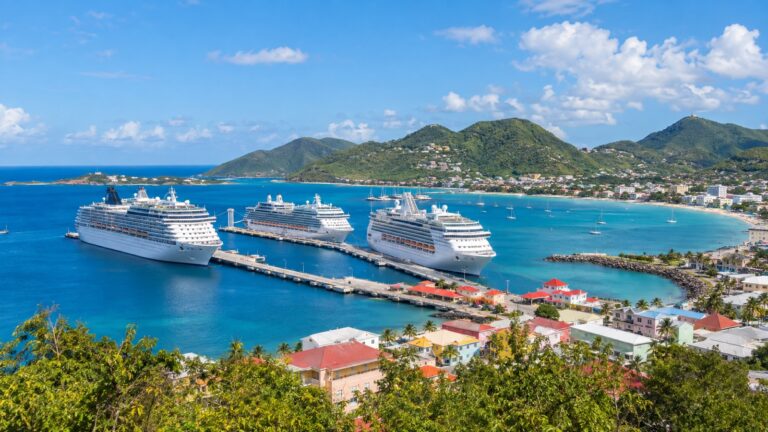 Philipsburg cruise ship piers at Port St. Maarten with white cruise ships beside blue Great Bay and green hills