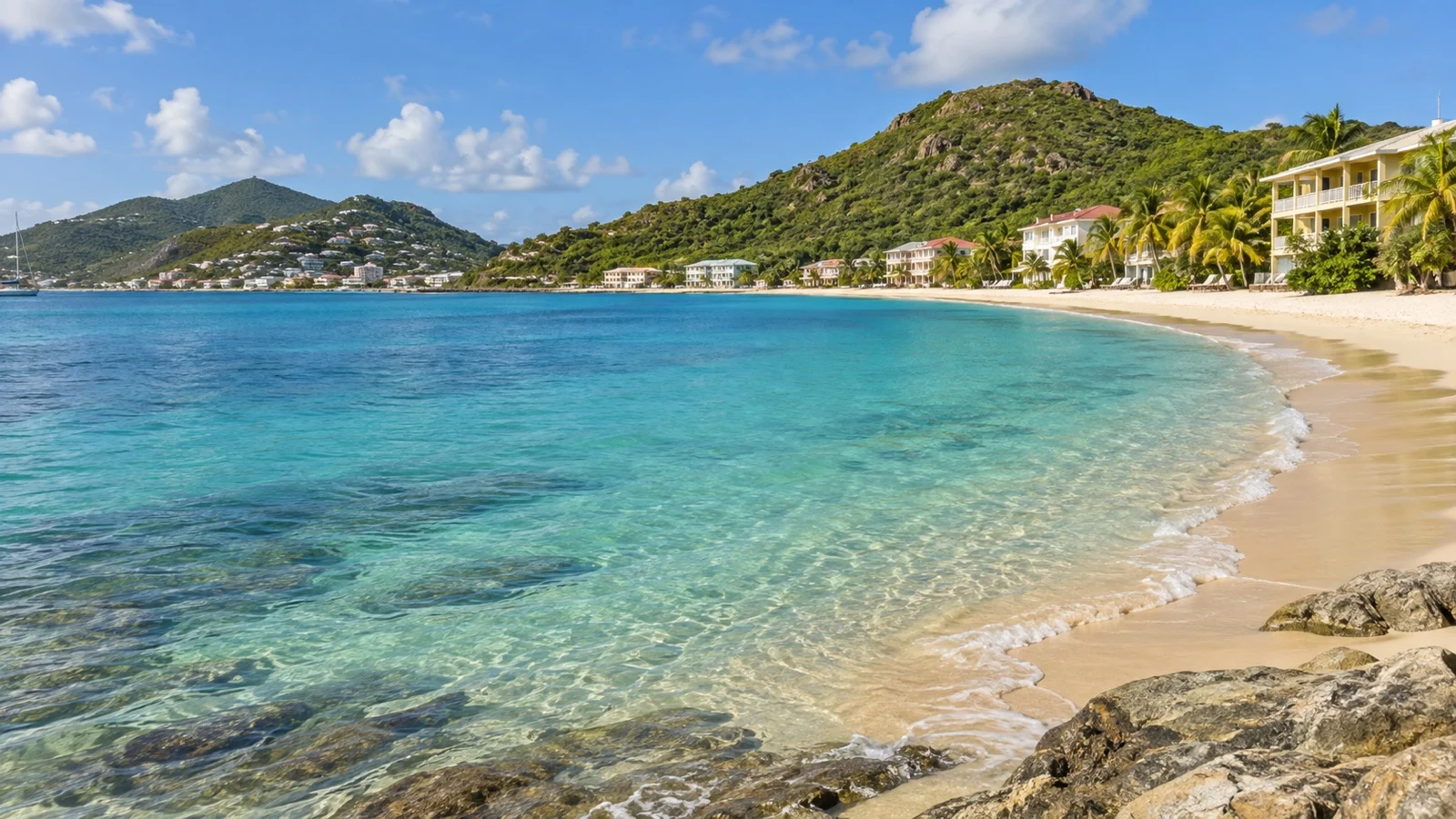Little Bay near Philipsburg, sheltered sandy beach with low beachfront hotels and green headlands