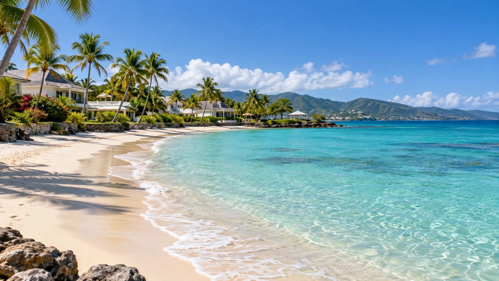 Sainte-Anne beach in Guadeloupe with elegant low resort buildings, palms and clear turquoise water