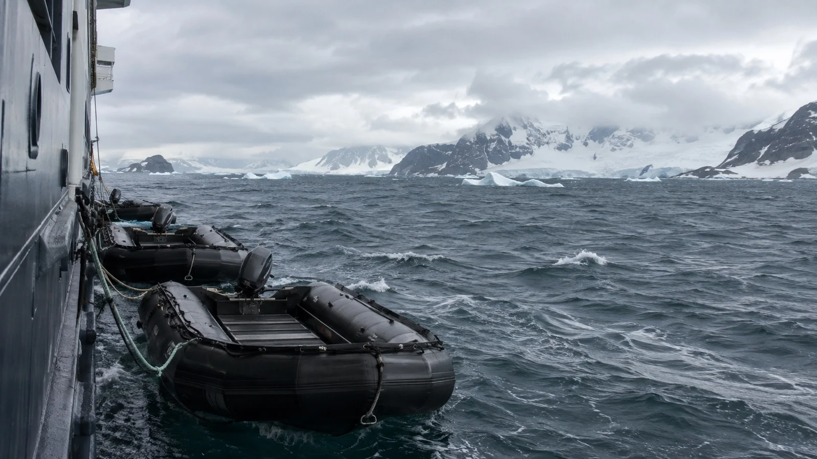 Zodiac landing boats off icy coast in rough weather