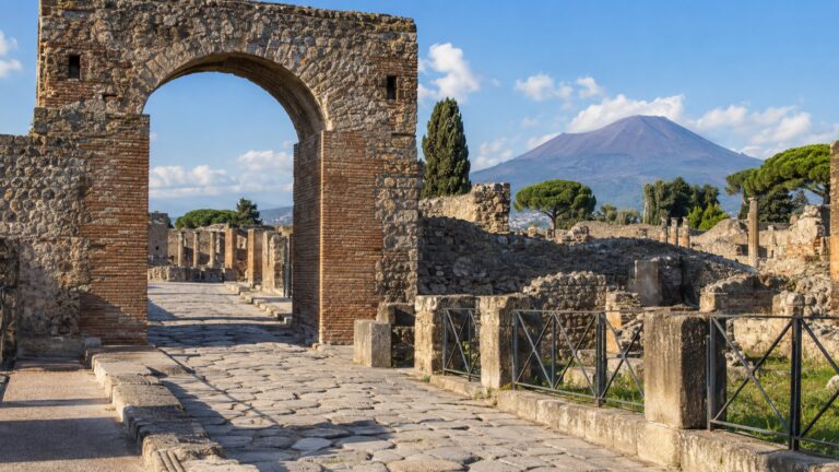 Stone entrance route into Pompeii with Vesuvius in the distance