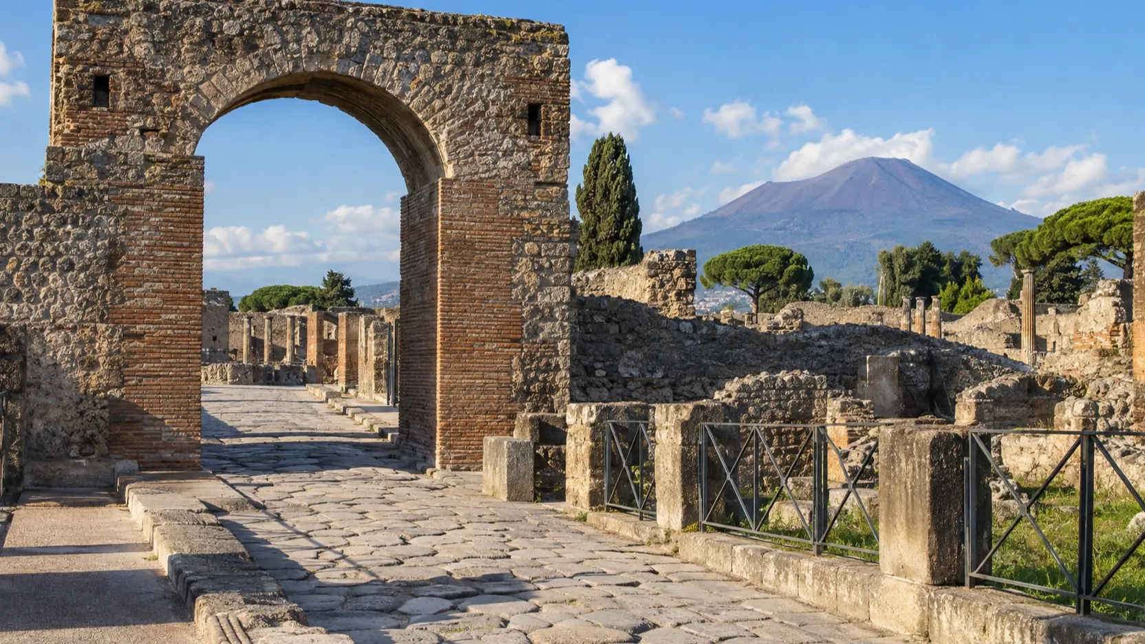 Stone entrance route into Pompeii with Vesuvius in the distance