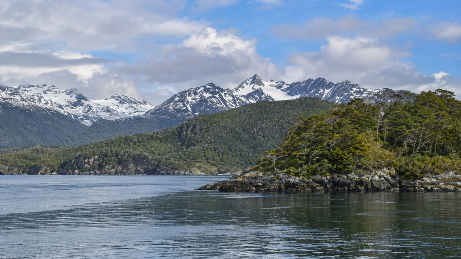 Beagle Channel and Navarino Island remote forested coast near Puerto Williams with snow-dusted peaks, no people