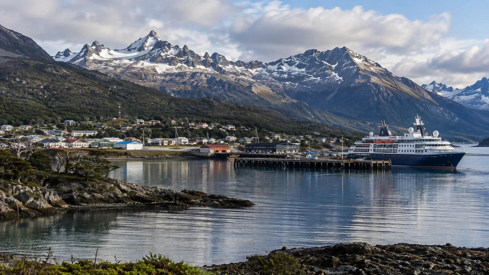 Puerto Williams Chile harbor on Beagle Channel with small expedition cruise ship, Navarino Island mountains and town, no people