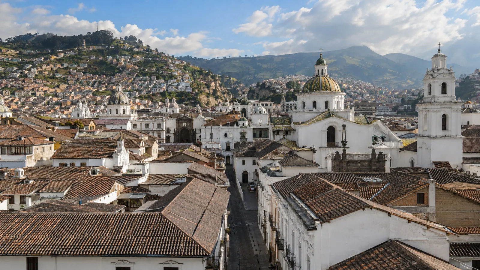 Quito UNESCO historic center with white colonial buildings, church domes and narrow stone streets viewed from above