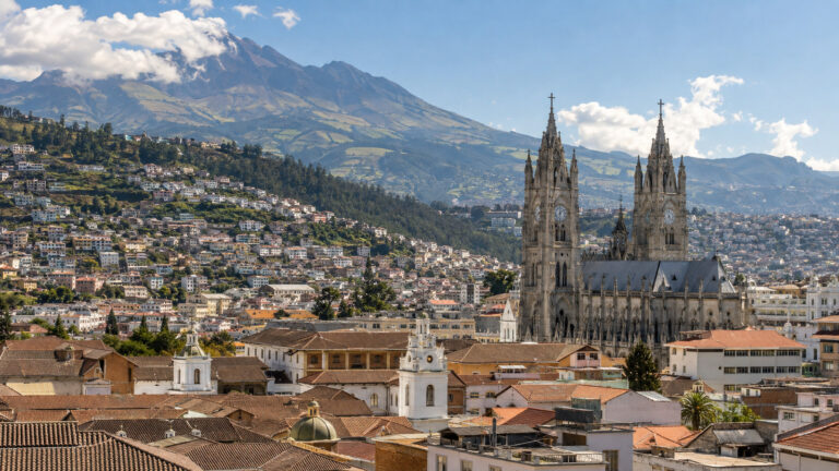 Wide elevated view over Quito Ecuador historic center in Andean valley with Basilica del Voto Nacional and mountain backdrop