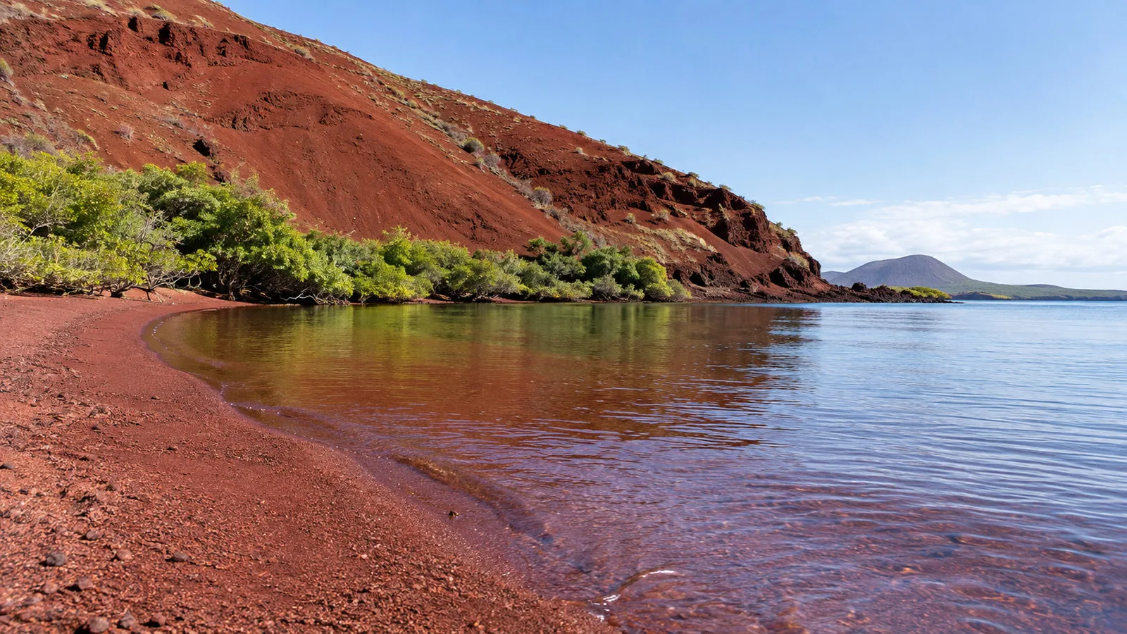 Rabida Island Galapagos red sand lagoon and sparse green coastal vegetation, no people