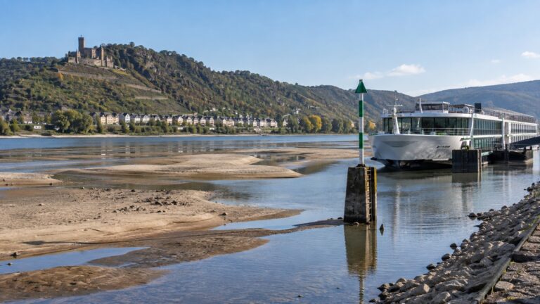 River cruise ship beside exposed Rhine riverbanks
