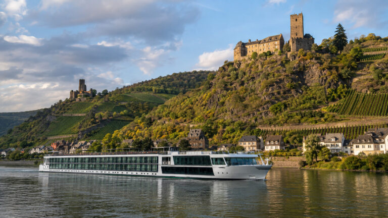 Rhine river cruise ship below castles and vineyards in Germany