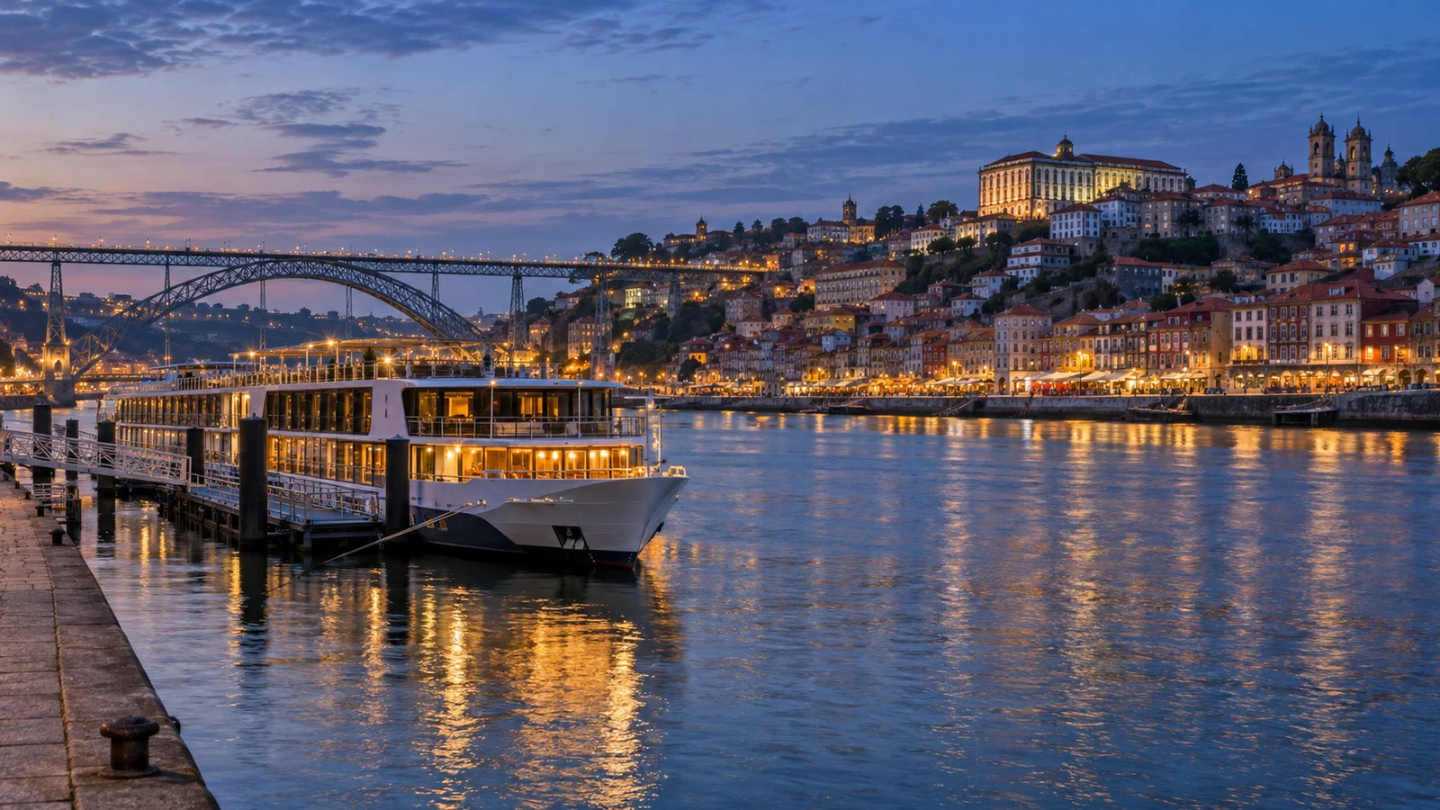 Porto and Vila Nova de Gaia riverfront at blue hour with a river cruise ship moored on the Douro
