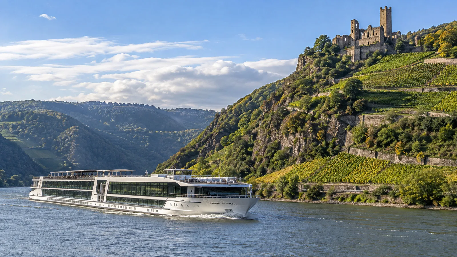 a river cruise ship passing the Middle Rhine Gorge with terraced vineyards and hilltop castle in daylight