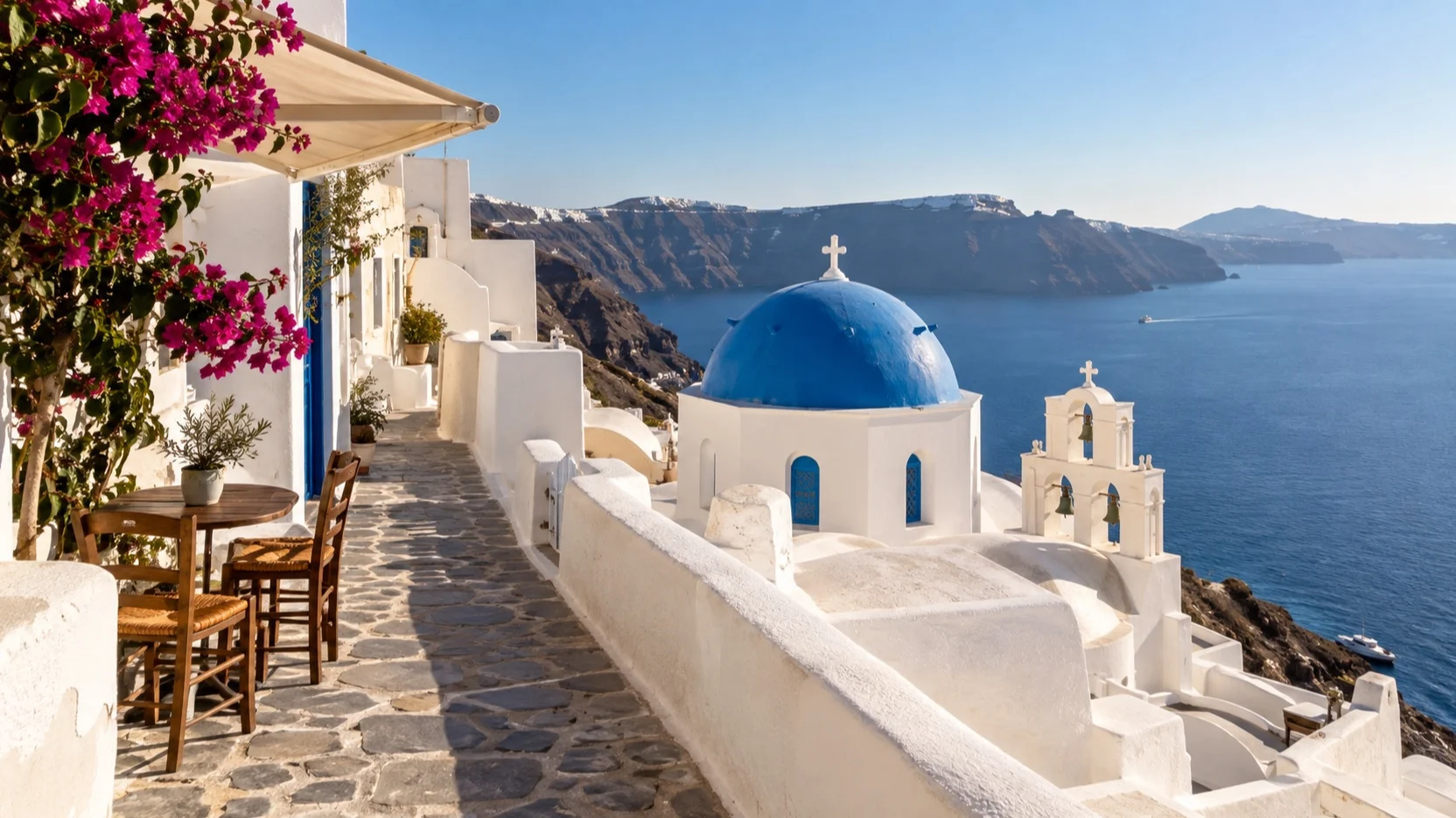 Quiet Santorini caldera lane beside a blue-domed church