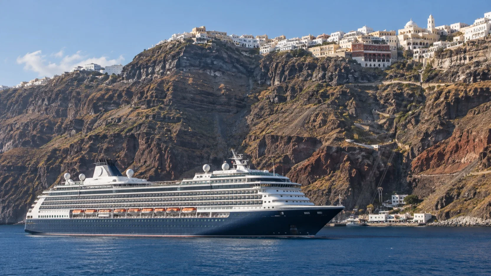 Cruise ship anchored beneath Fira's steep Santorini cliffs