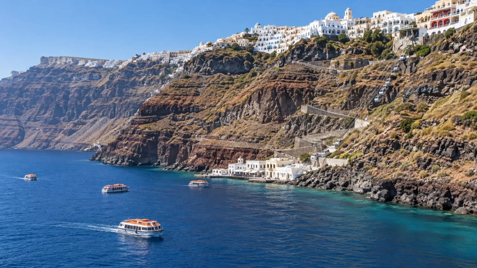 Cruise tenders below the steep whitewashed Fira cliff on Santorini