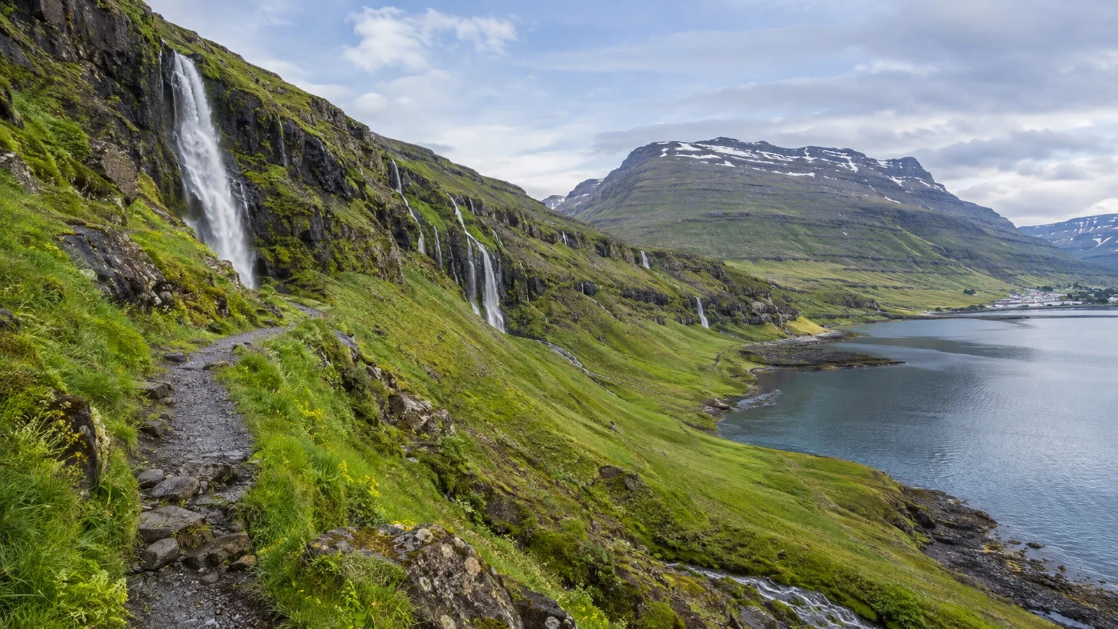 Waterfalls descending the green mountains above Seyðisfjörður