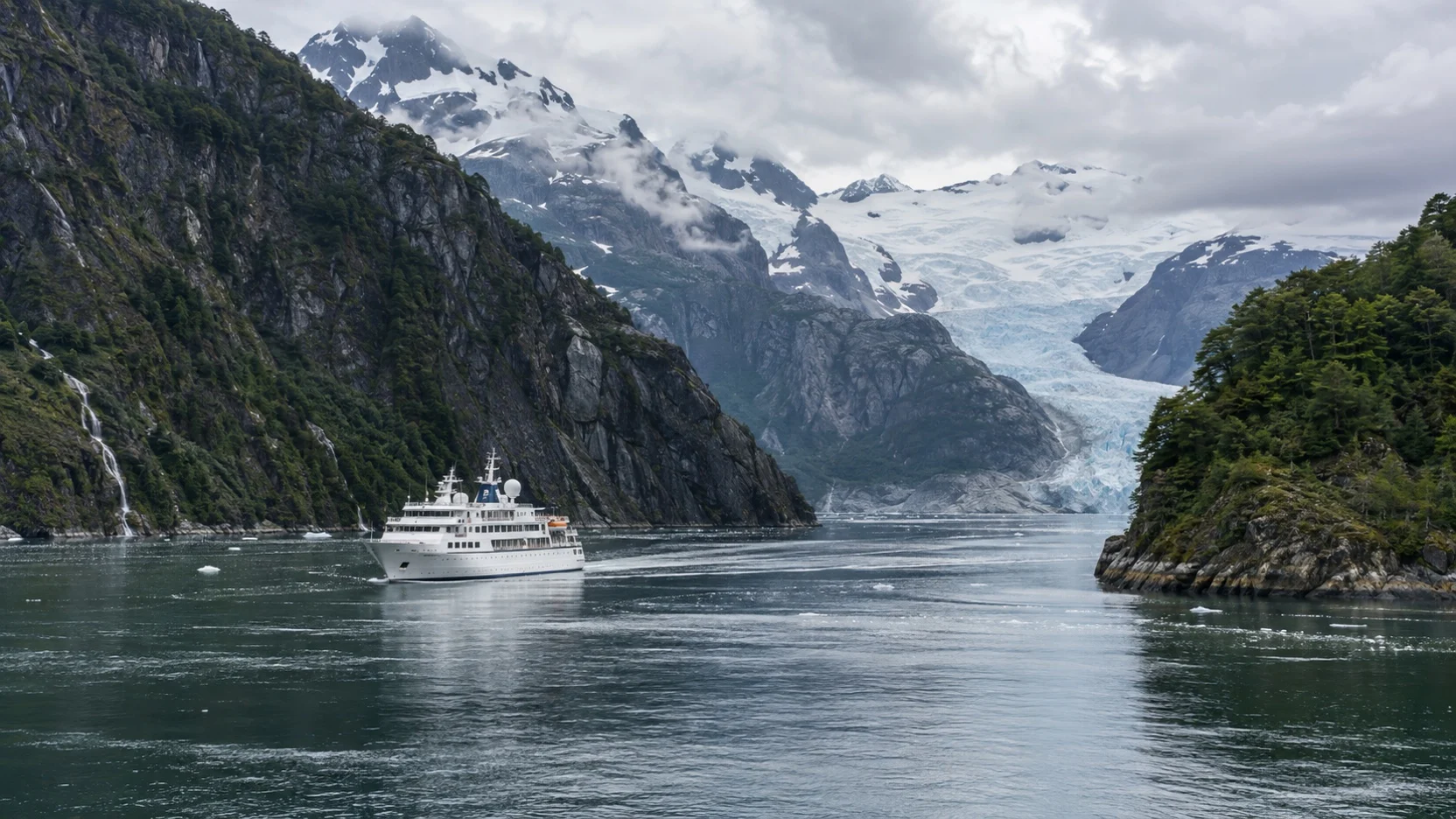 Small cruise ship sailing through a glacial fjord in Chilean Patagonia